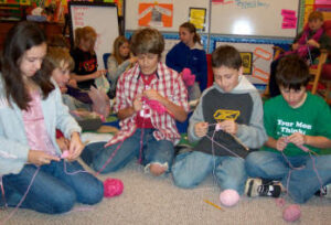 Group of kids learning to knit