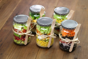 Mason jars filled with food and bow tied with a spoon